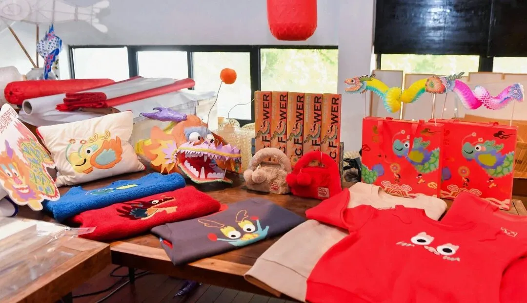 Dragon-themed childrenswear and accessories displayed together on a table.